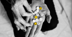Hand holding medication pills with smile emojis